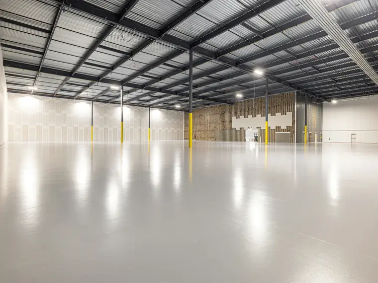 An empty warehouse interior with a polished concrete floor