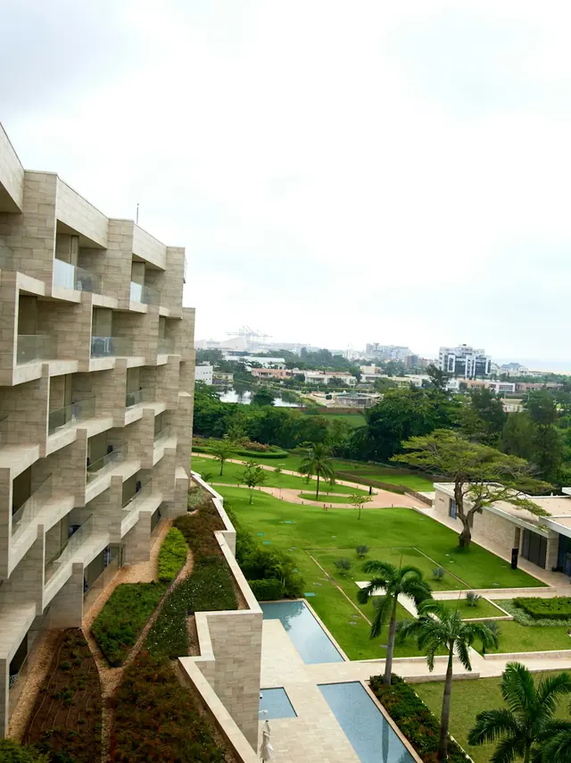 A terraced resort building above a pool and landscaped grounds
