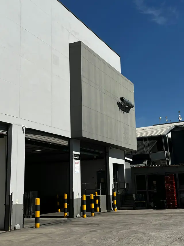 The loading bay of an industrial building with bollards across the apron